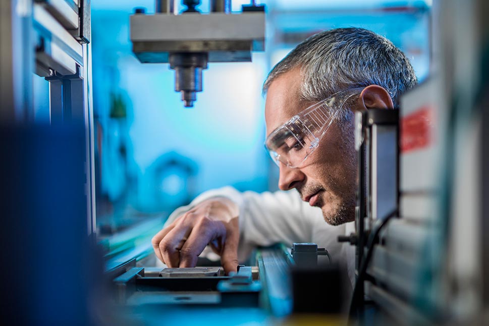 Engineer examining machine part on a production line in a factory